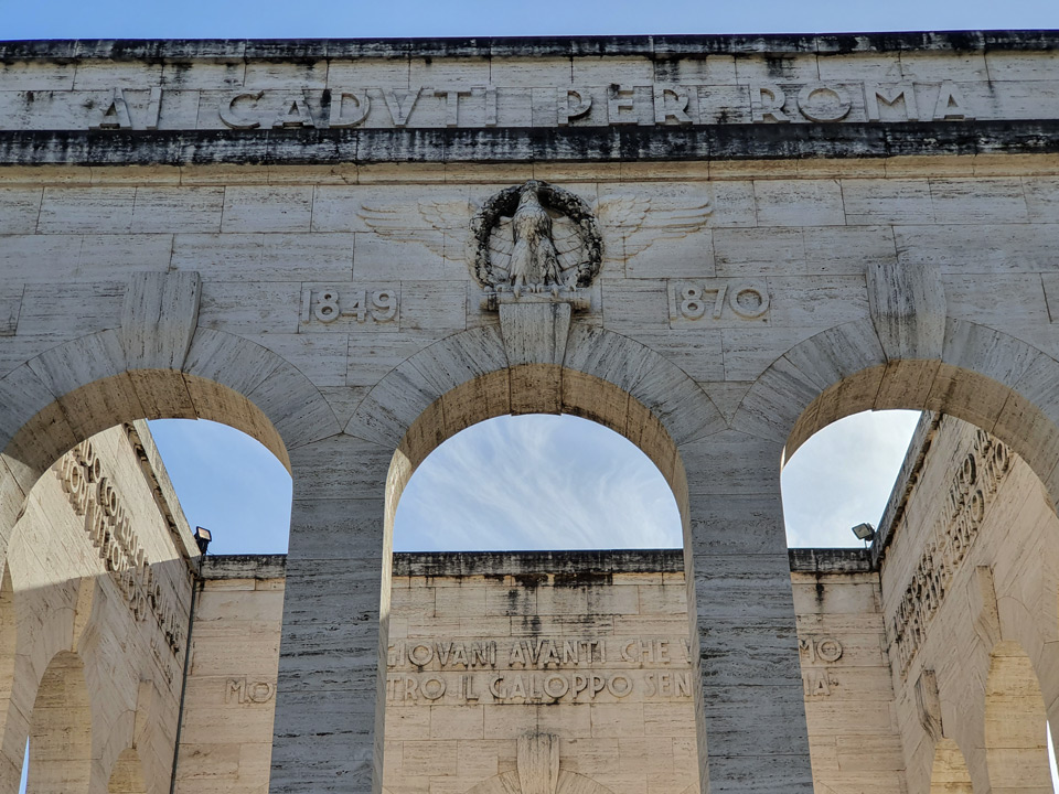 Надпись Ai Caduti per Roma и даты 1849 и 1870 над арками мавзолея-оссуария Гарибальди